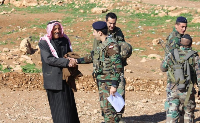 A tribal elder and a uniformed officer shaking hands during a field engagement